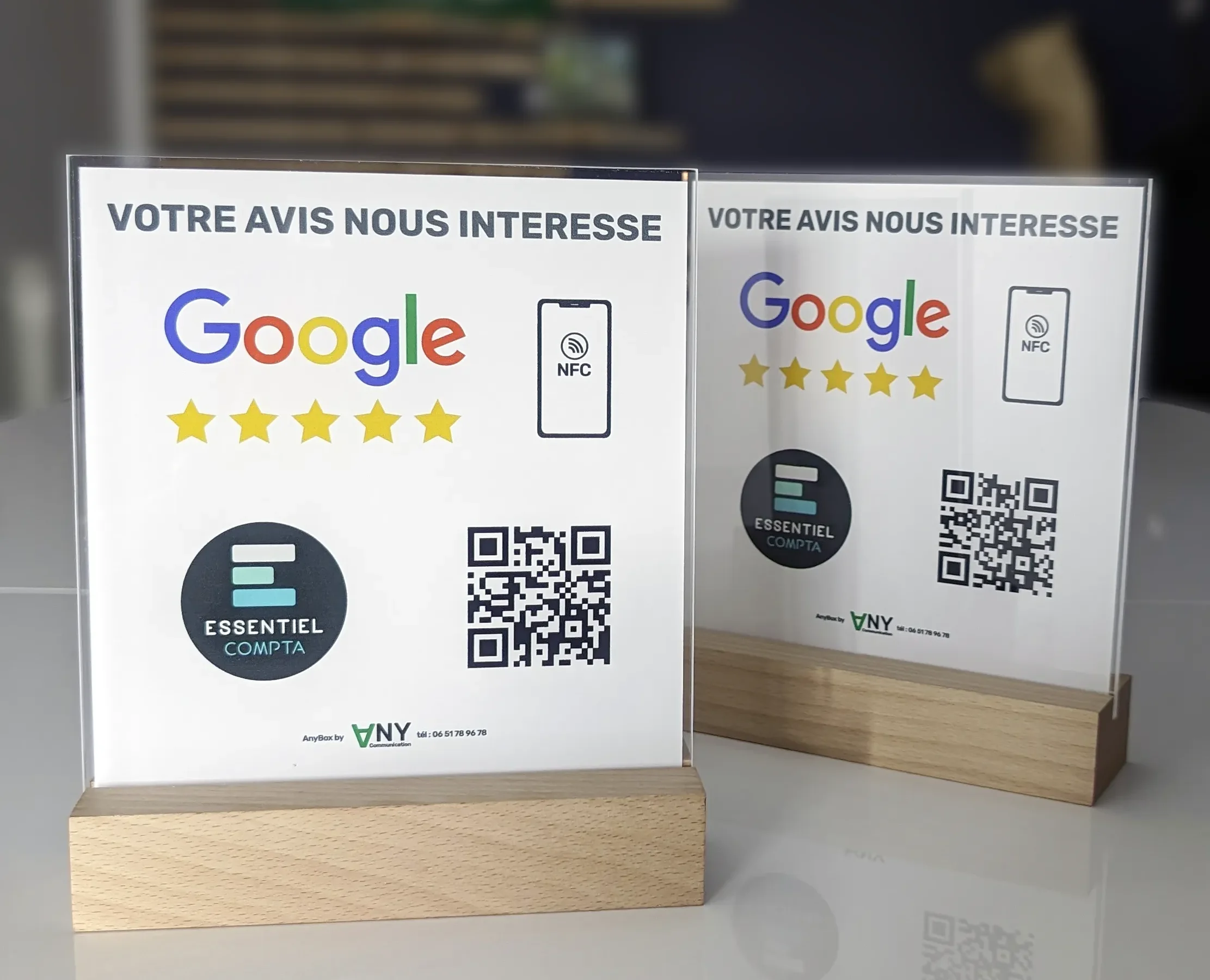 AnyBox, un récupérateur d'avis personnalisé avec le logo de Google et des étoiles de notation, des icônes NFC et QR code pour faciliter les retours clients, présenté sur un comptoir